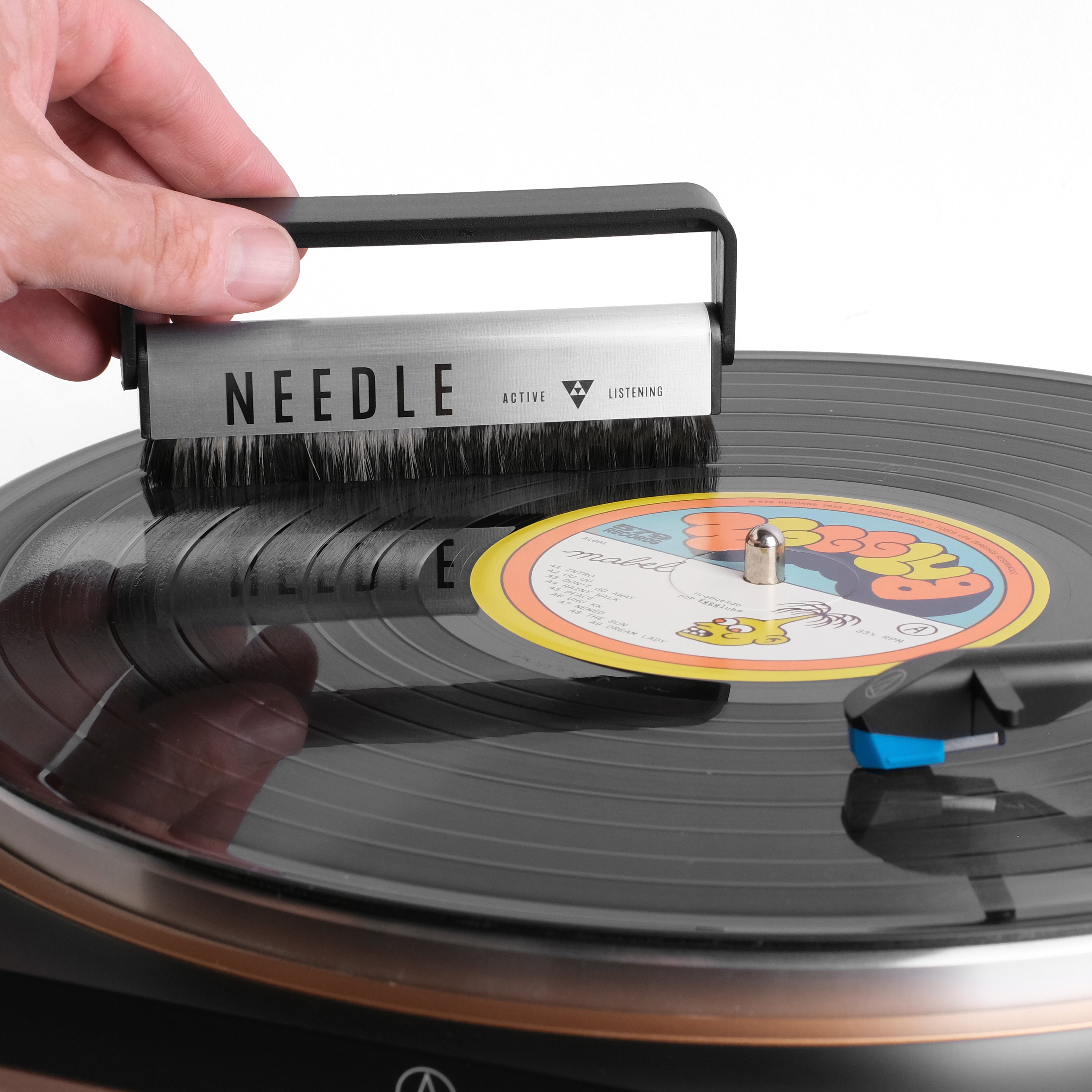 Escobilla Needle en uso sobre disco de vinilo, eliminando polvo y electricidad estática
