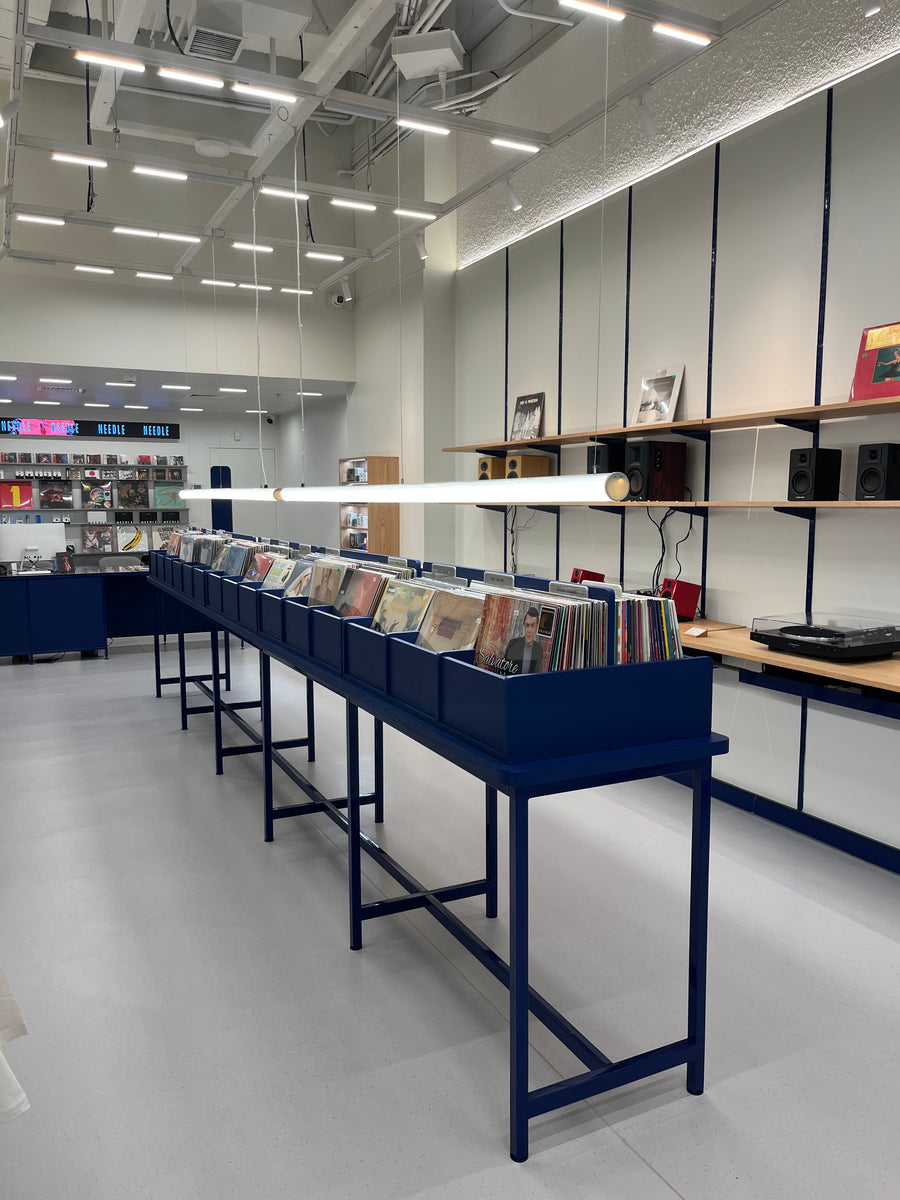 Interior de la tienda Needle Mallplaza Egaña, con bateas de vinilos y parlantes